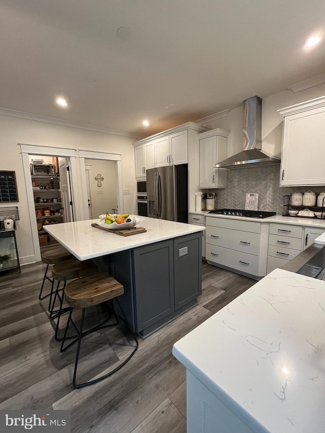 16801 Chalet Ct, Chesterfield, VA 23832 - kitchen featuring wall chimney range hood, stainless steel appliances, a center island, white cabinetry, and dark wood-style floors