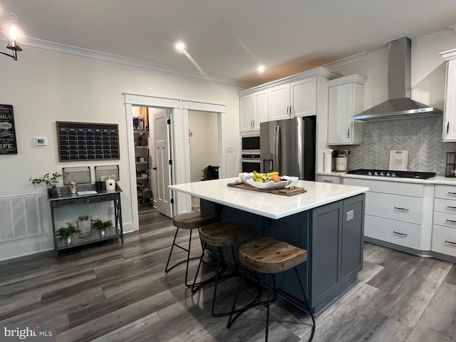 16801 Chalet Ct, Chesterfield, VA 23832 - kitchen featuring wall chimney exhaust hood, stainless steel appliances, crown molding, white cabinetry, and a center island
