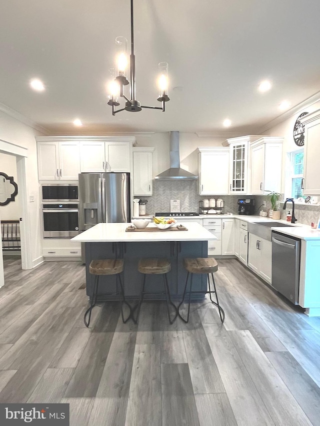 16801 Chalet Ct, Chesterfield, VA 23832 - kitchen featuring wall chimney range hood, stainless steel appliances, a sink, crown molding, and a kitchen breakfast bar