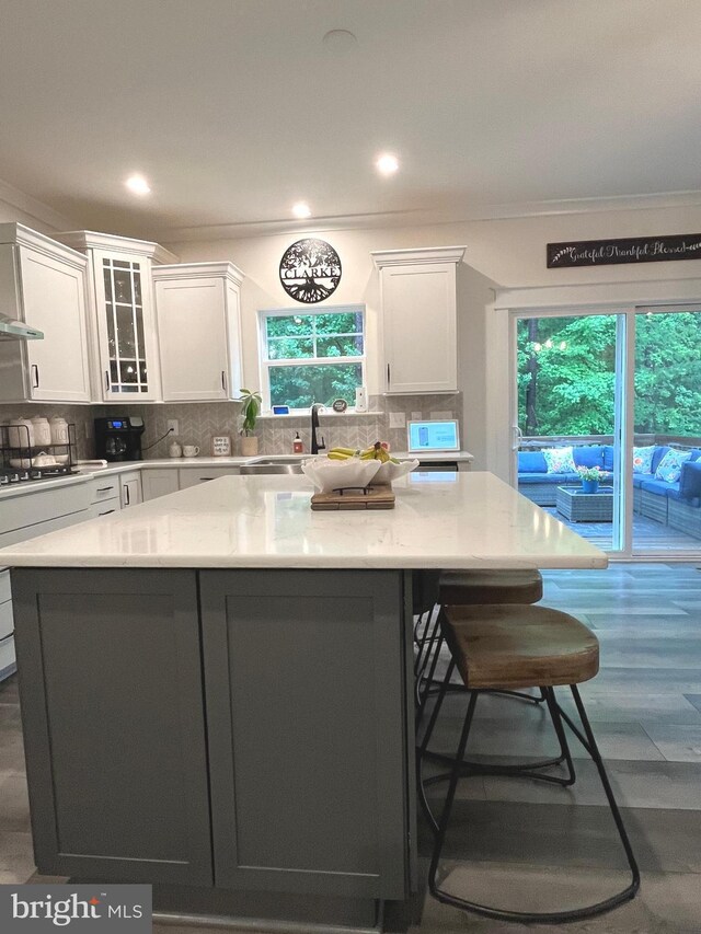 16801 Chalet Ct, Chesterfield, VA 23832 - kitchen with a kitchen breakfast bar, white cabinets, a center island, tasteful backsplash, and ornamental molding
