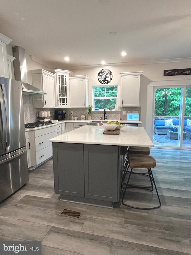 16801 Chalet Ct, Chesterfield, VA 23832 - kitchen featuring freestanding refrigerator, wall chimney range hood, white cabinetry, crown molding, and a sink