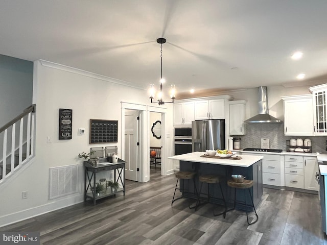 16801 Chalet Ct, Chesterfield, VA 23832 - kitchen featuring wall chimney exhaust hood, appliances with stainless steel finishes, white cabinets, light countertops, and crown molding