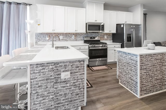 644 Lakemont Dr, Glen Burnie, MD 21060 - kitchen with appliances with stainless steel finishes, a sink, a peninsula, dark wood-style flooring, and backsplash