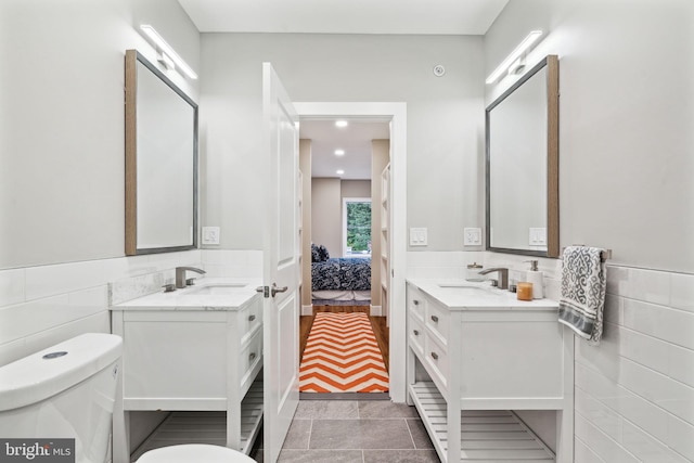 6210 Clearview St, Philadelphia, PA 19138 - bathroom with toilet, tile walls, two vanities, recessed lighting, and a wainscoted wall