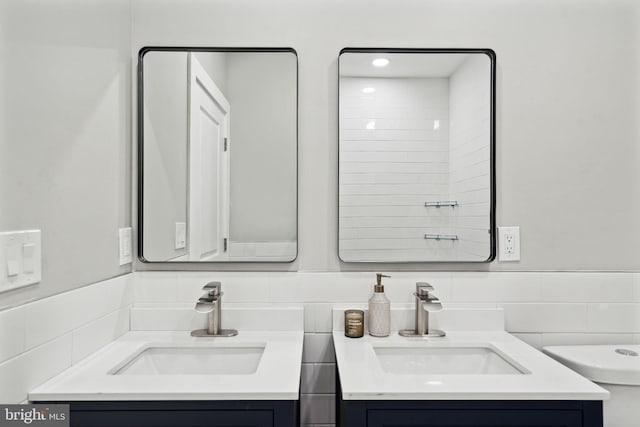 6210 Clearview St, Philadelphia, PA 19138 - bathroom with two vanities, tile walls, decorative backsplash, toilet, and a wainscoted wall