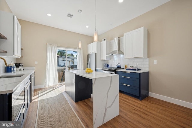 6210 Clearview St, Philadelphia, PA 19138 - kitchen with wall chimney range hood, appliances with stainless steel finishes, decorative backsplash, a sink, and light wood finished floors