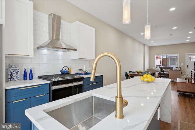 6210 Clearview St, Philadelphia, PA 19138 - kitchen featuring wall chimney exhaust hood, stainless steel gas stove, dark wood-style floors, blue cabinetry, and recessed lighting