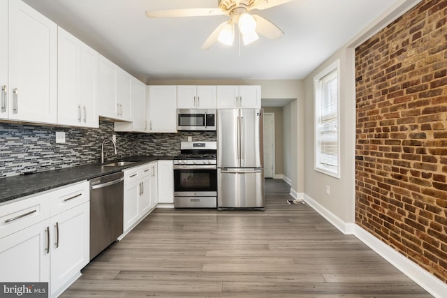 2808 Orleans St, Baltimore, MD 21224 - kitchen with appliances with stainless steel finishes, baseboards, a ceiling fan, a sink, and light wood-type flooring