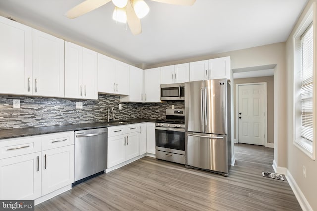 2808 Orleans St, Baltimore, MD 21224 - kitchen featuring stainless steel appliances, a sink, decorative backsplash, ceiling fan, and dark countertops