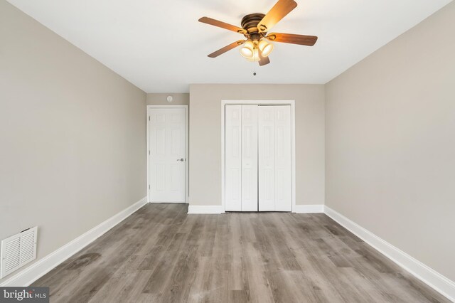 2808 Orleans St, Baltimore, MD 21224 - unfurnished bedroom with wood finished floors, a closet, baseboards, and a ceiling fan