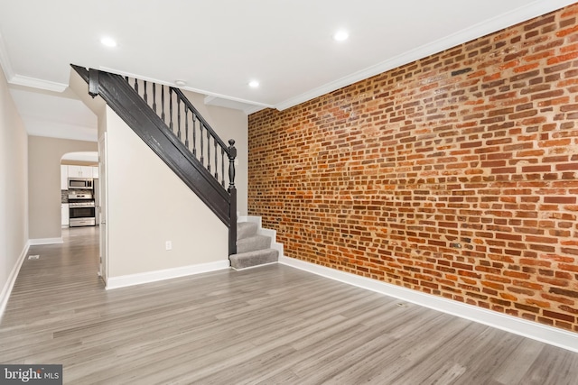 2808 Orleans St, Baltimore, MD 21224 - unfurnished living room with arched walkways, light wood-type flooring, stairs, ornamental molding, and baseboards