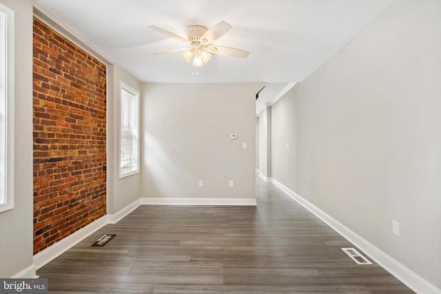 2808 Orleans St, Baltimore, MD 21224 - unfurnished room featuring brick wall, ceiling fan, dark wood-type flooring, and baseboards