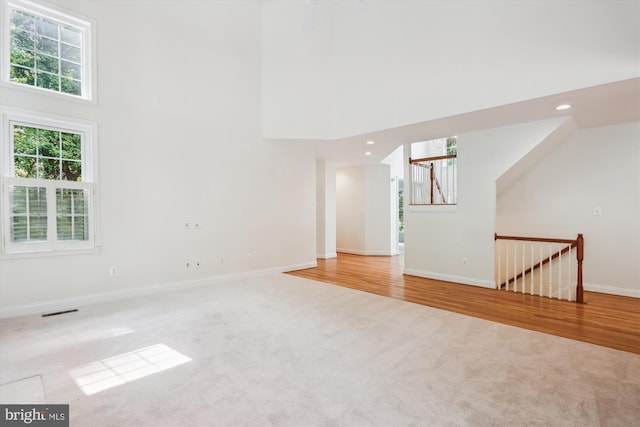 14908 Little Bennett Dr, Clarksburg, MD 20871 - unfurnished living room with a high ceiling, carpet, baseboards, recessed lighting, and wood finished floors