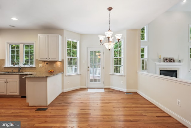14908 Little Bennett Dr, Clarksburg, MD 20871 - kitchen featuring light wood-style floors, a chandelier, a sink, dark stone countertops, and decorative backsplash