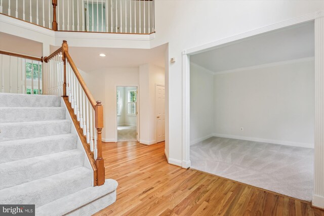14908 Little Bennett Dr, Clarksburg, MD 20871 - stairway with plenty of natural light, baseboards, wood finished floors, a towering ceiling, and crown molding