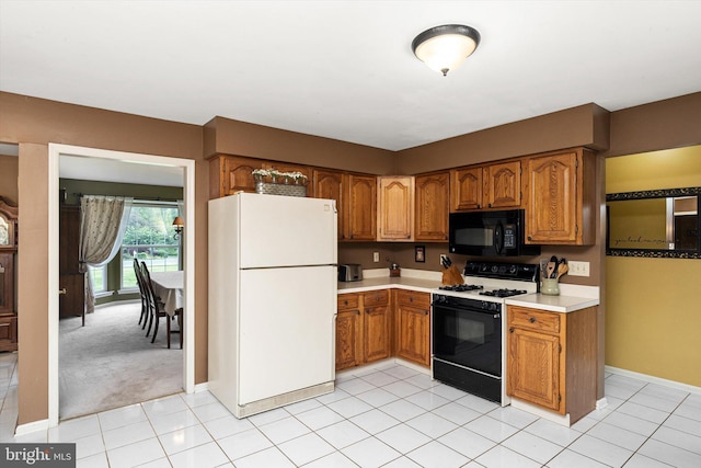 124 Kirschling Dr, Woolwich Twp, NJ 08085 - kitchen featuring freestanding refrigerator, black microwave, gas range oven, brown cabinets, and light countertops