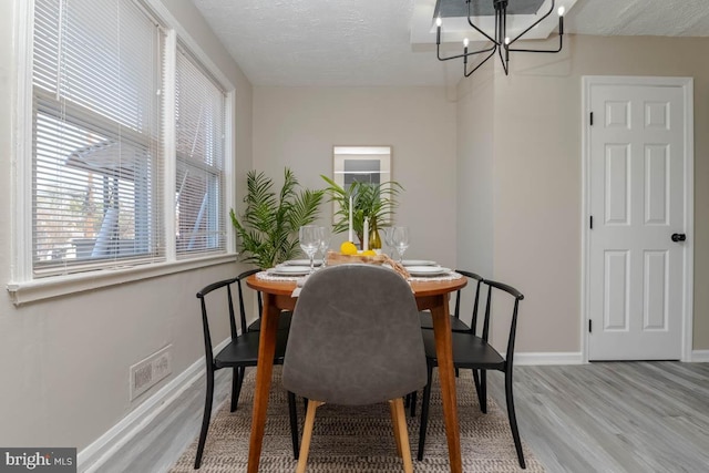 3548 Mcshane Way, Dundalk, MD 21222 - dining room with wood finished floors, a chandelier, baseboards, and a textured ceiling