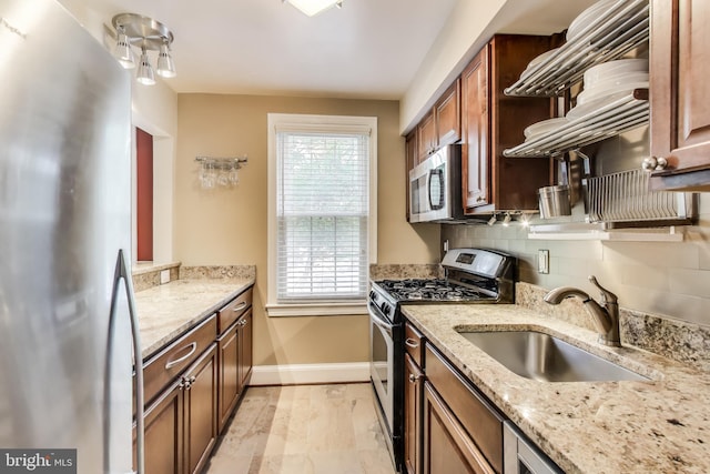 2725 Ordway St NW Unit 2, Washington, DC 20008 - kitchen featuring appliances with stainless steel finishes, a sink, baseboards, backsplash, and light stone counters