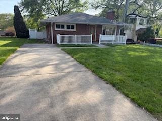 7686 Briar Ln, Pasadena, MD 21122 - view of front of house featuring a front lawn, a porch, and concrete driveway