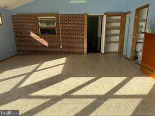 7686 Briar Ln, Pasadena, MD 21122 - unfurnished living room featuring vaulted ceiling and tile patterned flooring