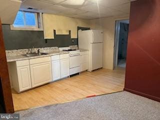 7686 Briar Ln, Pasadena, MD 21122 - kitchen featuring white appliances, light countertops, a sink, a drop ceiling, and light wood finished floors