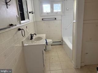 7686 Briar Ln, Pasadena, MD 21122 - full bathroom featuring toilet, vanity, a bath, tile patterned flooring, and tile walls