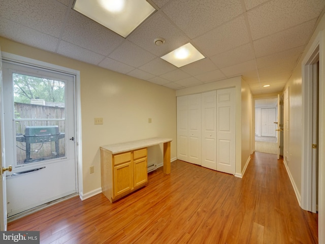 9407 7th St N, Laurel, MD 20723 - unfurnished bedroom featuring light wood-style flooring, a closet, baseboards, baseboard heating, and a drop ceiling