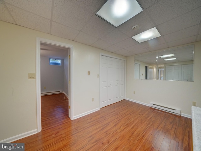 9407 7th St N, Laurel, MD 20723 - empty room with a baseboard radiator, wood finished floors, baseboards, and a drop ceiling