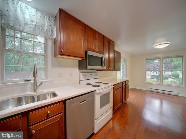 9407 7th St N, Laurel, MD 20723 - kitchen featuring stainless steel appliances, baseboard heating, a sink, light countertops, and wood finished floors