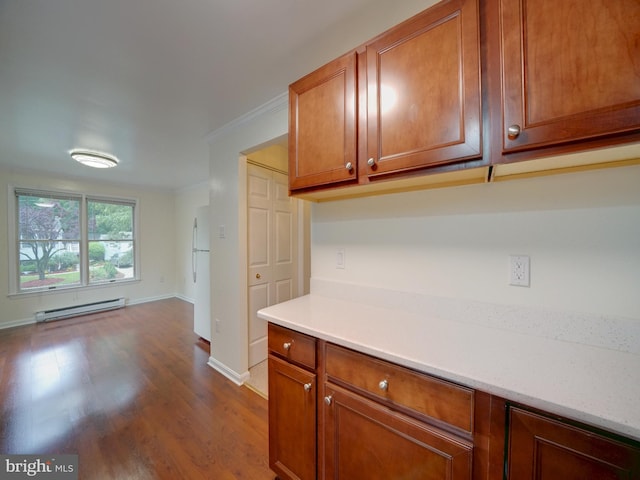 9407 7th St N, Laurel, MD 20723 - kitchen with a baseboard radiator, light countertops, dark wood-type flooring, brown cabinets, and crown molding