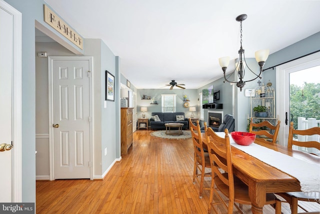 14 Baron Ct, Stafford, VA 22554 - dining area with light wood-type flooring, a chandelier, a lit fireplace, and a ceiling fan