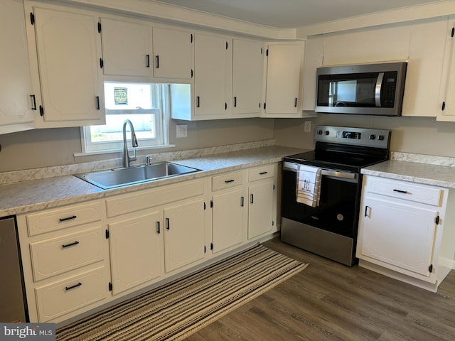 203 4th Ave, Burnham, PA 17009 - kitchen featuring stainless steel appliances, a sink, white cabinetry, and dark wood-style flooring