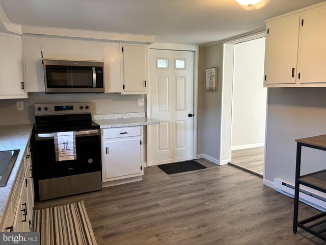 203 4th Ave, Burnham, PA 17009 - kitchen featuring appliances with stainless steel finishes, dark wood-style flooring, baseboards, light countertops, and white cabinetry