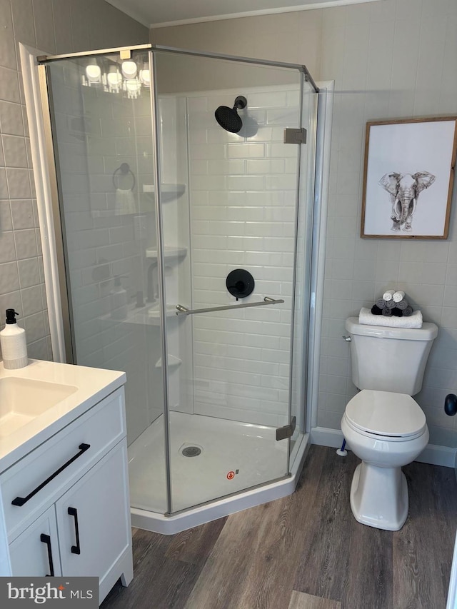 203 4th Ave, Burnham, PA 17009 - full bath with wood finished floors, a stall shower, vanity, toilet, and tile walls