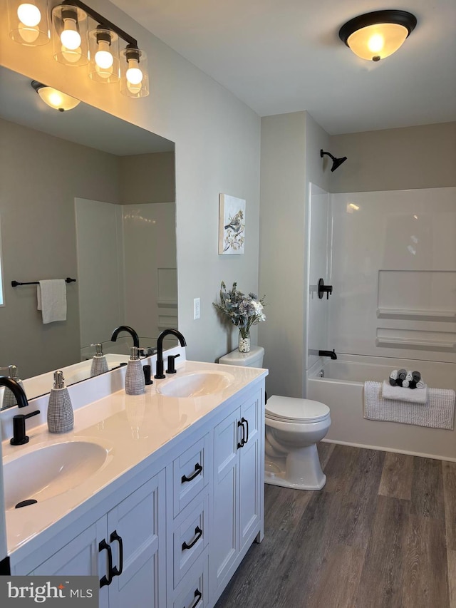 203 4th Ave, Burnham, PA 17009 - bathroom featuring wood finished floors, toilet, double vanity, and washtub / shower combination