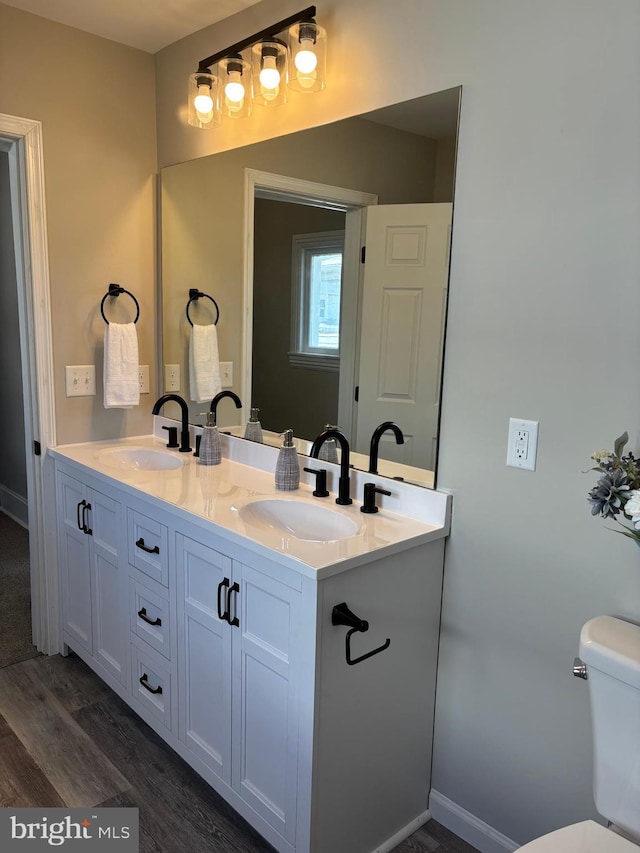 203 4th Ave, Burnham, PA 17009 - bathroom featuring double vanity, wood finished floors, and toilet