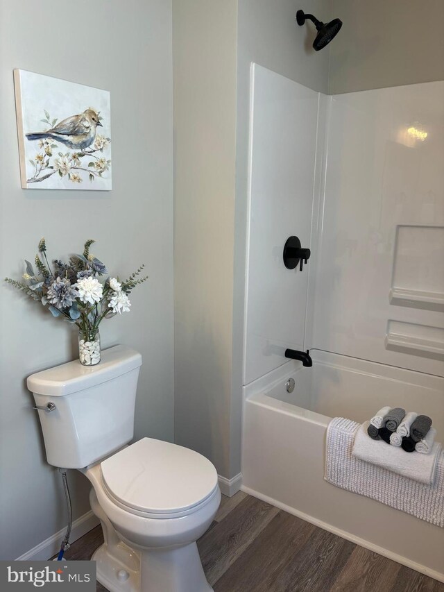 203 4th Ave, Burnham, PA 17009 - bathroom featuring baseboards, wood finished floors, toilet, and bathing tub / shower combination