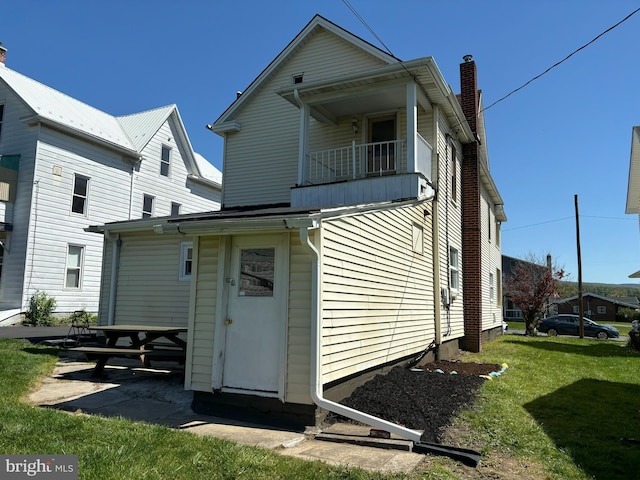 203 4th Ave, Burnham, PA 17009 - rear view of property featuring a balcony, a chimney, and a yard