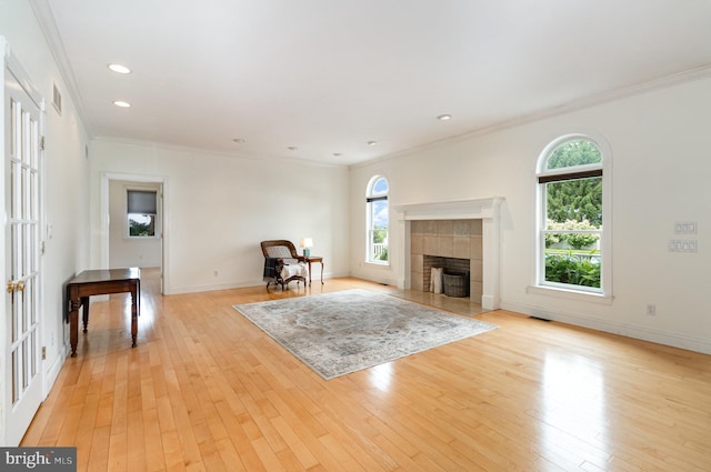 148 Lawn Rd, Palmyra, PA 17078 - unfurnished living room featuring healthy amount of natural light, crown molding, light wood-style flooring, a tiled fireplace, and baseboards