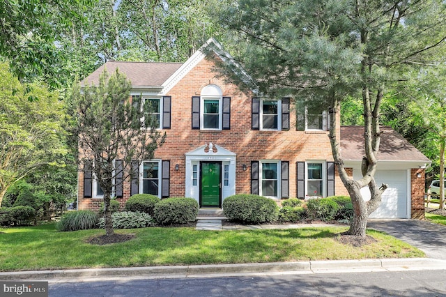 14901 Running Ridge Ln, Silver Spring, MD 20906 - colonial inspired home featuring an attached garage, brick siding, asphalt driveway, a front yard, and a shingled roof