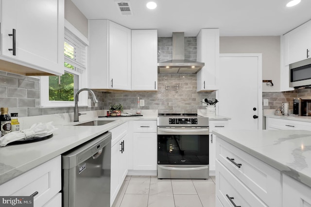 14901 Running Ridge Ln, Silver Spring, MD 20906 - kitchen with appliances with stainless steel finishes, wall chimney range hood, a sink, backsplash, and white cabinets
