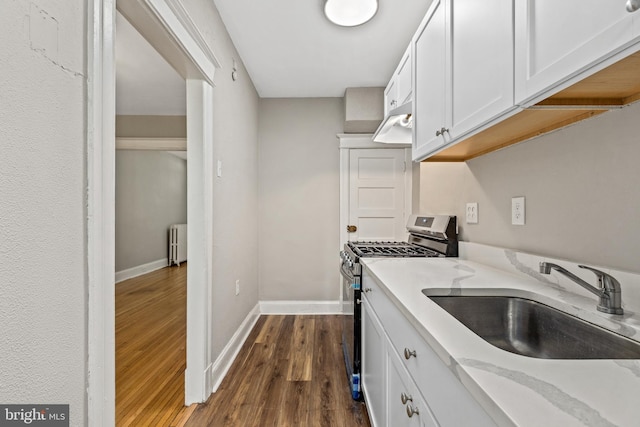 616 Hamilton St NW, Washington, DC 20011 - kitchen featuring gas range, radiator heating unit, a sink, dark wood-type flooring, and white cabinets