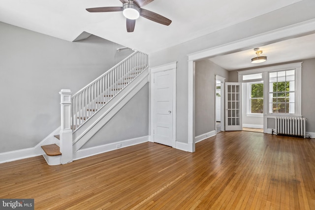 616 Hamilton St NW, Washington, DC 20011 - unfurnished living room with radiator, stairway, a ceiling fan, baseboards, and hardwood / wood-style floors