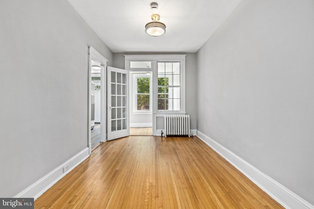 616 Hamilton St NW, Washington, DC 20011 - empty room with radiator, light wood-style flooring, and baseboards