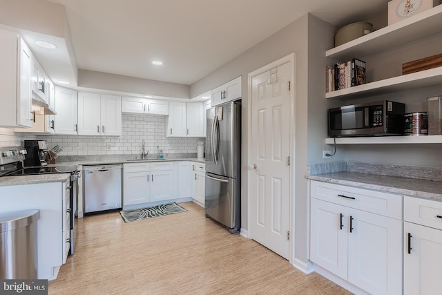 21008 Strawrick Ter, Ashburn, VA 20147 - kitchen with appliances with stainless steel finishes, a sink, white cabinetry, decorative backsplash, and light wood-type flooring