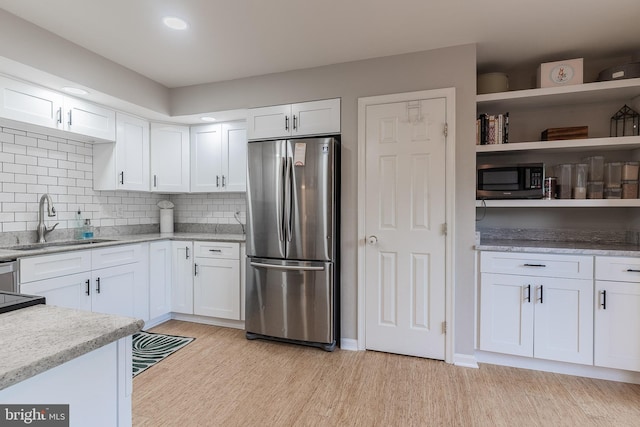 21008 Strawrick Ter, Ashburn, VA 20147 - kitchen with freestanding refrigerator, a sink, black microwave, white cabinetry, and light wood-style floors