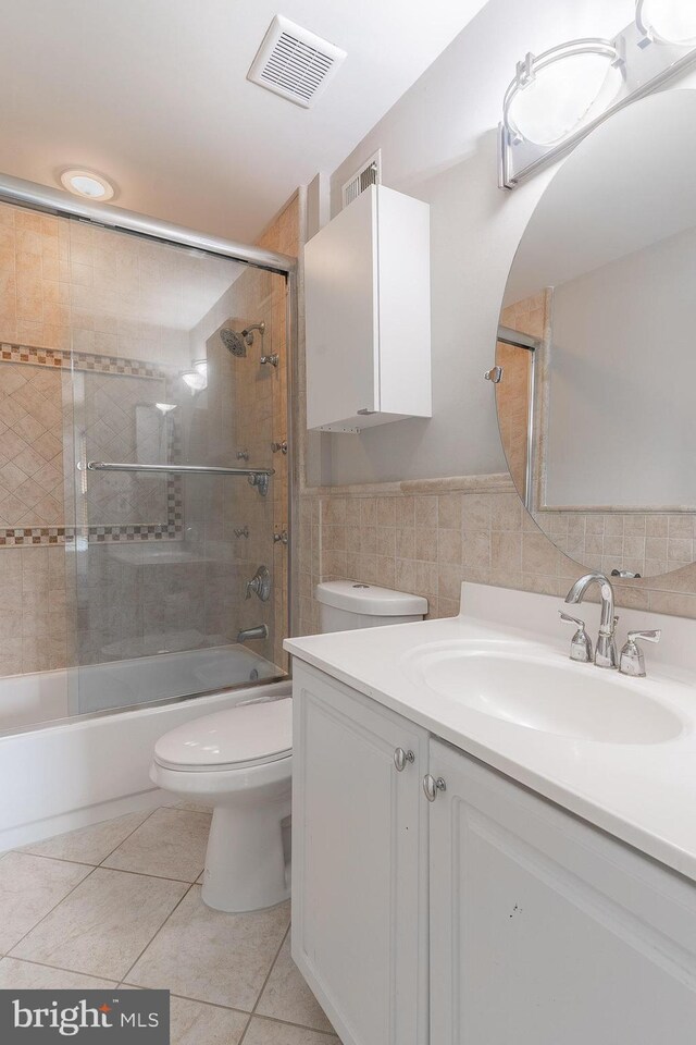 21008 Strawrick Ter, Ashburn, VA 20147 - bathroom featuring toilet, vanity,  shower combination, tile walls, and tile patterned flooring