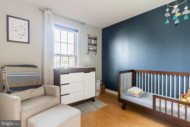 21008 Strawrick Ter, Ashburn, VA 20147 - bedroom featuring light wood-style flooring, baseboards, and a nursery area