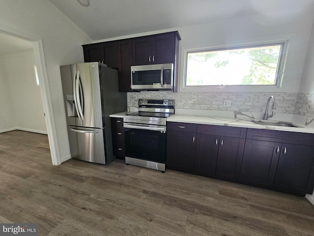 6603 Byrnes Dr, Mclean, VA 22101 - kitchen featuring stainless steel appliances, vaulted ceiling, decorative backsplash, a sink, and dark wood-style floors