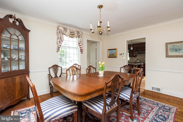 114 Bellemore Rd, Baltimore, MD 21210 - dining area featuring a chandelier, ornamental molding, wallpapered walls, wood finished floors, and baseboards